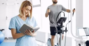 patient doing exercise spin bike gym with therapist